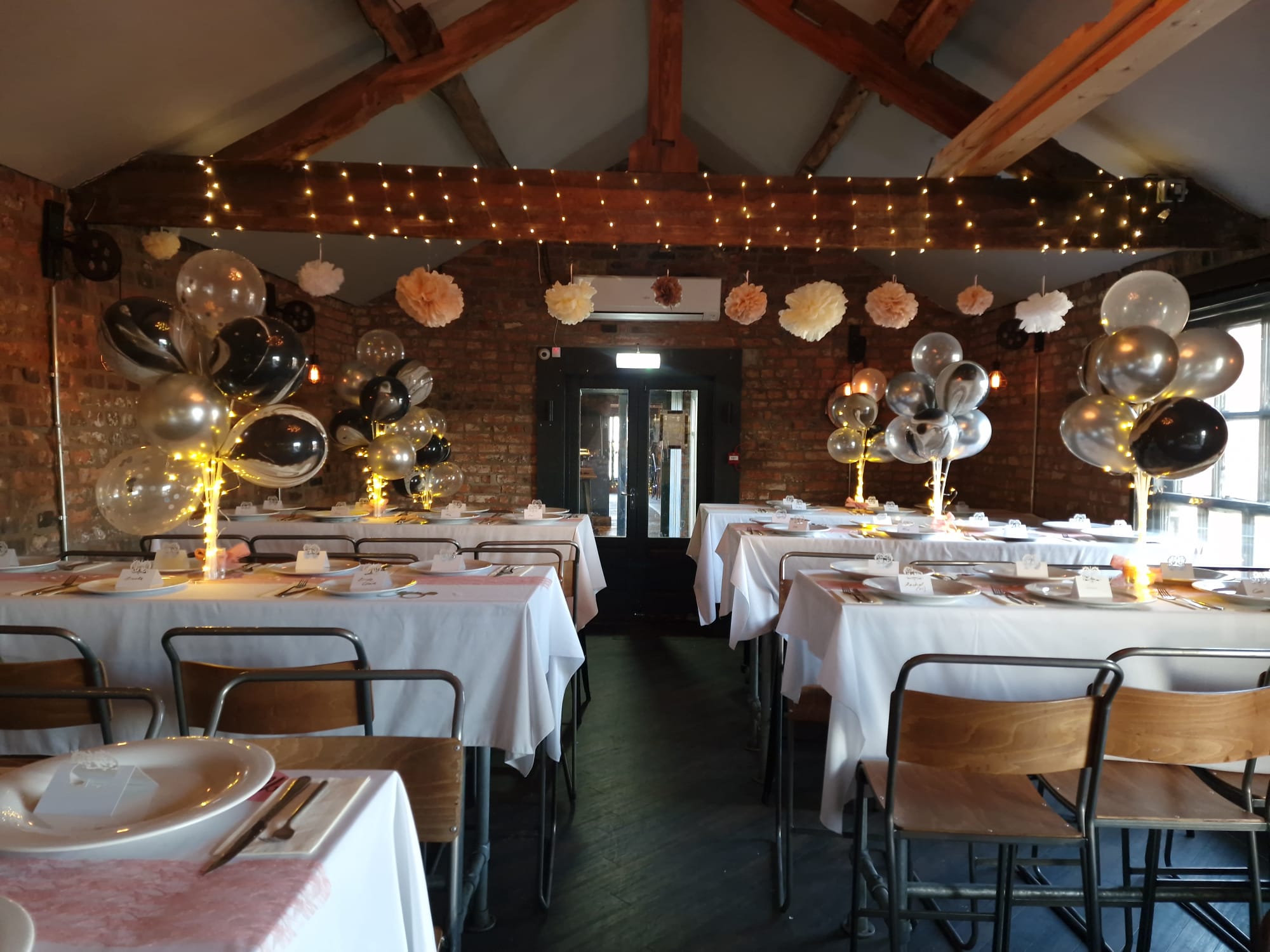 The Coachhouse private hire room — vaulted ceiling, fairy lights and balloon decorations